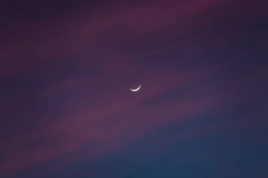 Hilal ay ve pembe bulutlarla gün batımı