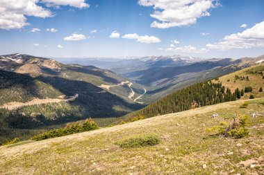 Dağları ve mavi gökyüzü olan güzel bir manzara.