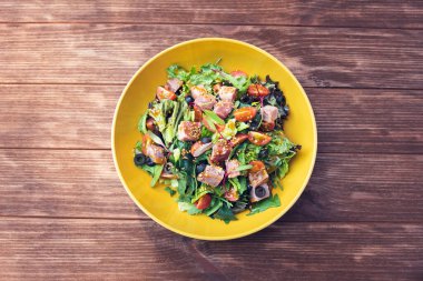 Tavuklu salata, sebze ve ahşap arka planda roka. en üstteki görünüm.