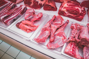 Kasap tezgahında bir sürü et parçası var.