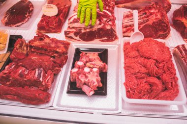 Bir kasap dükkanının tezgahında yeşil eldivenli eller