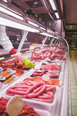 Bir kasap dükkanının tezgahında yeşil eldivenli eller