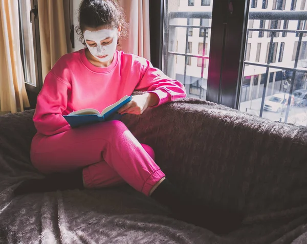 Young Woman White Face Mask Reading Book Sofa — Stock Photo, Image