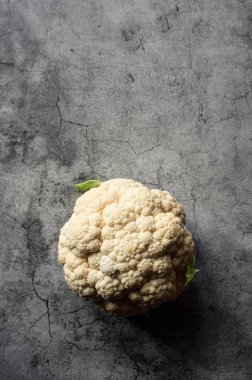 Gri taştan arka planda karnabahar başı resmi.