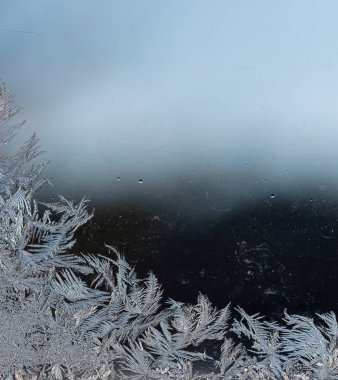 Bir kış günü pencere camındaki buz kalıplarını kapat.