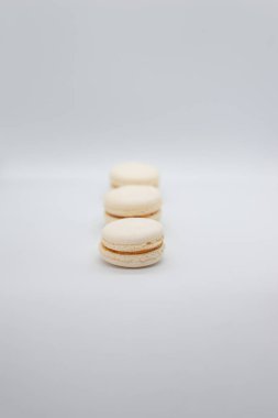 Beyaz zemin üzerinde sıra sıra dizilmiş kurabiyelerin yakın çekimi. Boşluğu kopyala