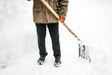 Kar kürekleyen bir adam kar fırtınasından sonra bahçesinden karı kaldırır.