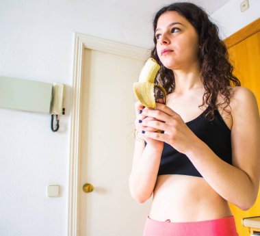 Genç bir kadın evde pencerelere kaslarını geriyor.