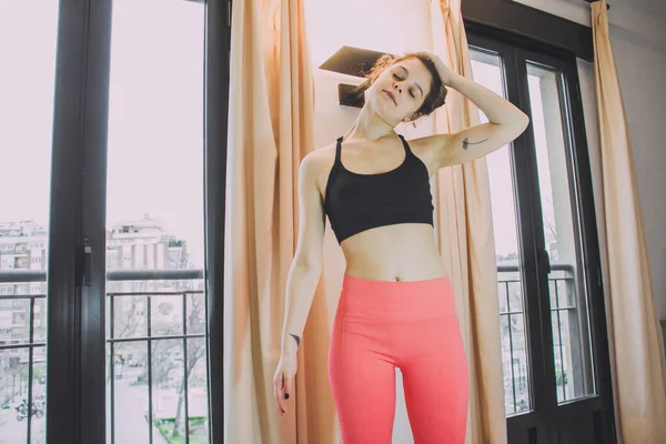 Mujer Joven Estirando Los Músculos Casa Contra Las Ventanas —  Fotos de Stock