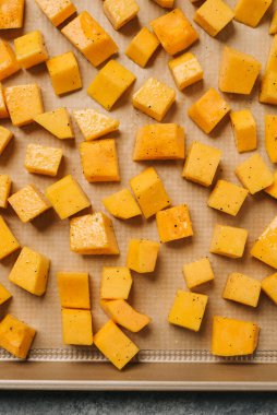 Çiğ balkabağı parçaları, baharatlı ve yağlı, pişirmeye hazır.