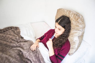 Hasta genç kadın yatakta yatıyor.