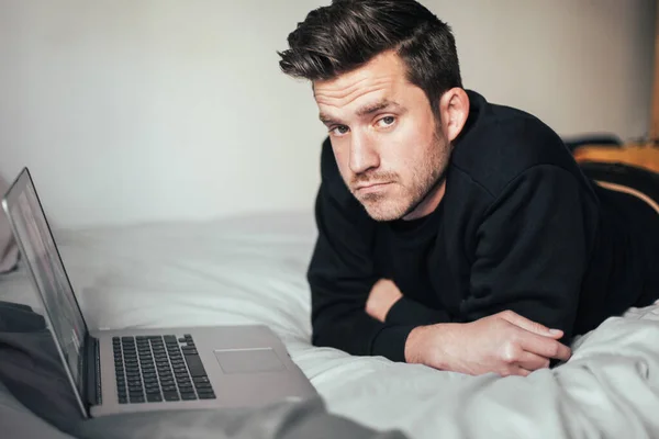 Young Man Looks Sad Lying Bed Laptop Video Call — Stok fotoğraf