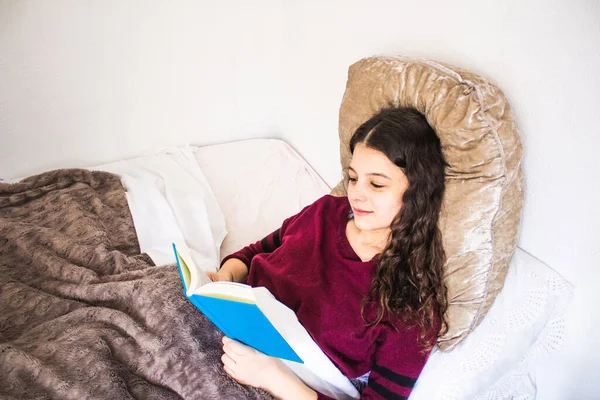 Jonge Vrouw Lezen Liggend Bed Met Een Blauw Boek — Stockfoto