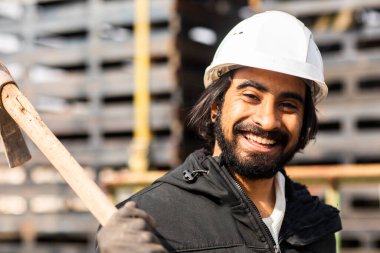 Dışarıda çalışan kasklı ve sakallı bir işçi.