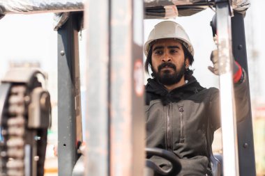 Dışarıda çalışan kasklı ve sakallı bir işçi.