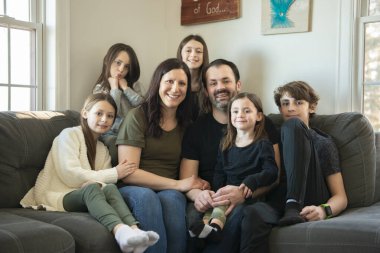 Yedi kişilik aile kanepede oturuyor..