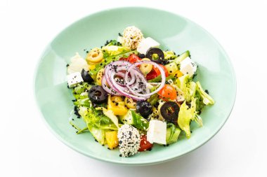 Beyaz arka planda yeşil tabakta Yunan salatası