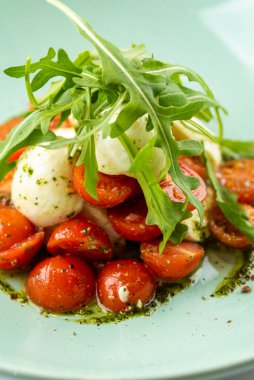 Taze salata roka, mozzarella ve kasede domates.