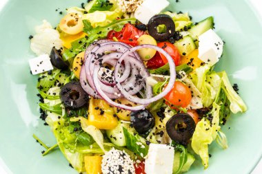 Beyaz arka planda yeşil tabakta Yunan salatası