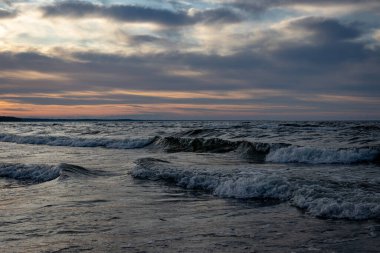 Baltık Denizi 'nin üzerindeki güzel altın bulutlu manzara, gün batımı çekimi.