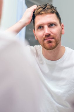 Genç adam sabahları aynayı yansıtır.