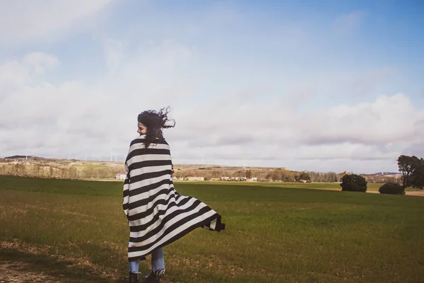 Tarlada Çizgili Battaniyeli Genç Bir Kadın Rüzgarda Hareket Ediyor — Stok fotoğraf
