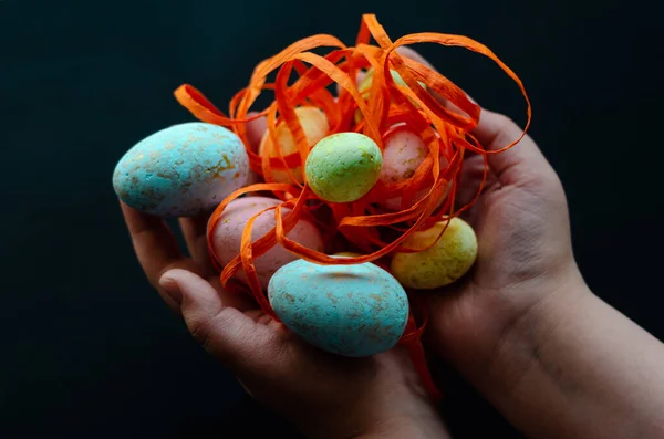 Huevos Pascua Con Cinta Naranja Las Manos Sobre Fondo Oscuro — Foto de Stock