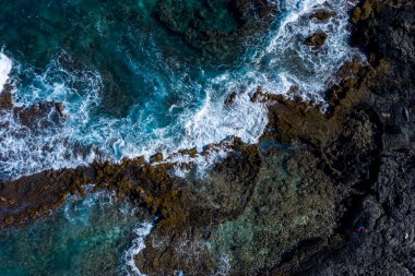 Güçlü bir gelgitin havadan görünüşü Hawaii 'nin kayalık kıyılarıyla buluşuyor.