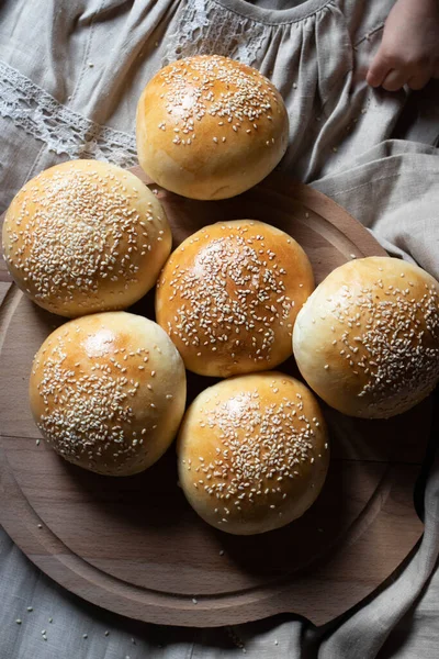 Hamburgerbrötchen Mit Sesam Auf Einer Leinenunterwäsche Und Einem Holzbrett — Stockfoto