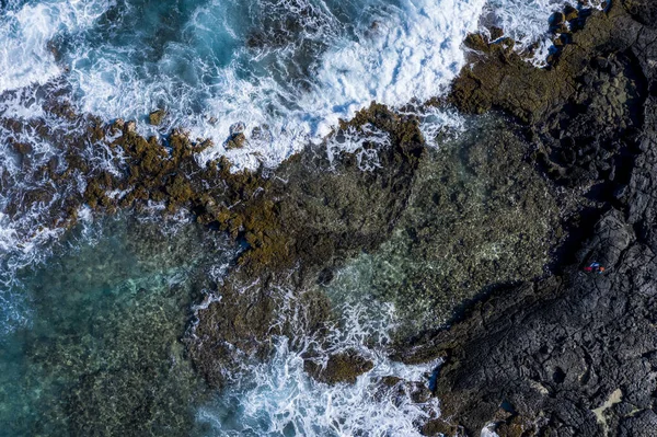 Drone photo of ocean waves meeting the rocks