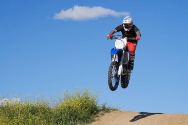Motokrosta motosikletle gösteri yapan adamın yan görüntüsü