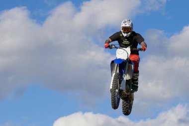 Motokrosta motosikletle gösteri yapan adamın yan görüntüsü