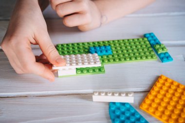 Kız renkli bloklardan inşaatçı topluyor