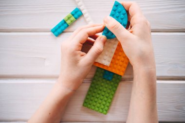 Kız renkli bloklardan inşaatçı topluyor