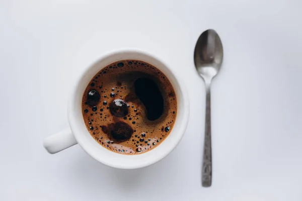 Uma Xícara Café Com Espuma Uma Colher Chá Fundo Branco — Fotografia de Stock