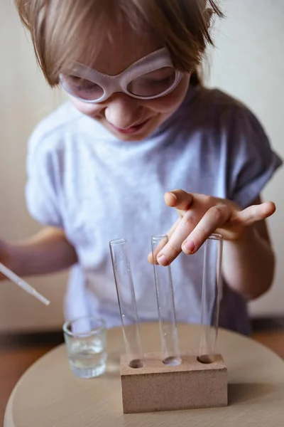 一个戴护目镜的女孩在家里做化学实验 — 图库照片