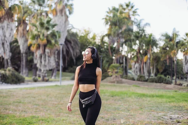 Young Woman Crop Top Headphones Walking Palm Park — Stock Fotó