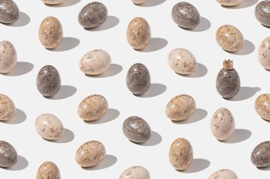 Açık gri arka planda süslü paskalya yumurtaları. Minimum konsept. İzometrik yerleşim.