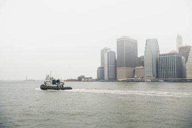 New York, ABD 'de sisli bir günde şehir merkezinde nehirde yüzen çağdaş tekne.