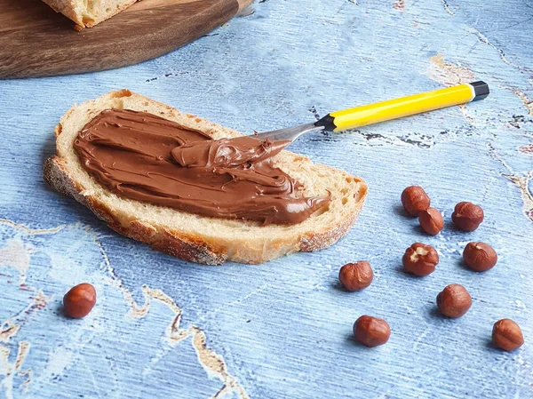 Pezzo Pane Tagliato Con Pasta Cioccolato Nocciole Coltello Giallo — Foto Stock