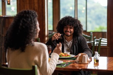 Masada oturan çift yemeğin tadını çıkarıyor.