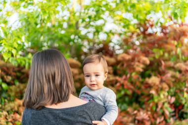 Parkta güzel bir kız annesine sarılıyor.