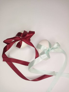 İki yumurta bordo ve turkuaz kurdeleyle süslenmiş.