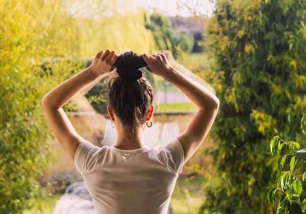 Woman Combing Her Bun Looking Out Window — Stock Photo, Image