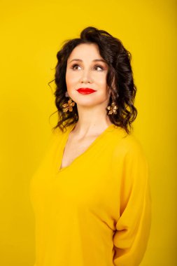 a young woman in a bright yellow jacket on a yellow background