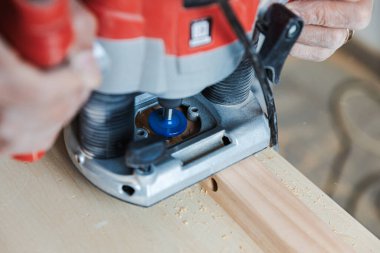 Marangozun elleri elektrikli bir planörü yakın görüyor.