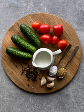 Çeri domates, salatalık, sarımsak, ekşi krema, ahşap tahtadaki baharatlar.