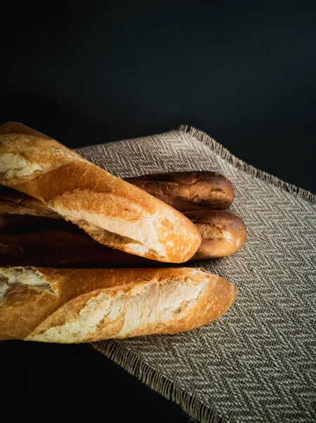 Bagetler siyah bir arka planda peçetenin üzerinde yatar.