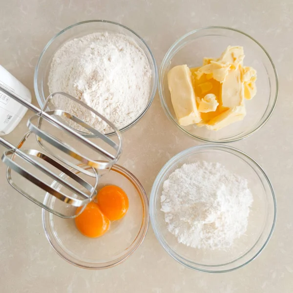 Four Bowls Eggs Flour Sugar Powder Butter Mixer Flat Lay — Stock Photo, Image