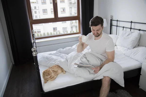 Молодий Чоловік Читає Газету Каву Ліжку Реальному Житті Кіт — стокове фото